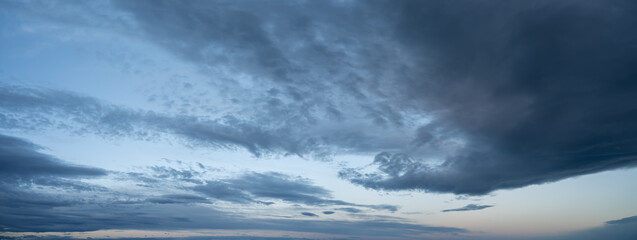 Wall Mural - panorama of evening clouds at blue hour starting just above the horizon