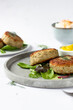 © Nemanja - Traditional Iceland fish burgers with mustard curry sauce and some green garnish on a grey tray