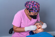 © ADDICTIVE STOCK - Focused ethnic dentist checking up teeth of elderly patient in clinic