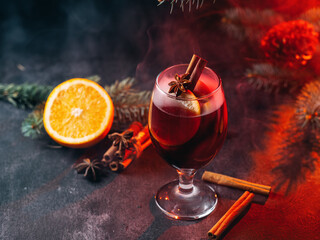 Wall Mural - Christmas mulled wine, red wine with spices and orange on the table. Steam from a hot drink. Holiday decor