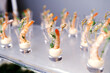 a lot of shrimp with white sauce in shot glasses