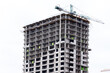 Crane tower at the construction site of a multi-storey residential building. Building concept