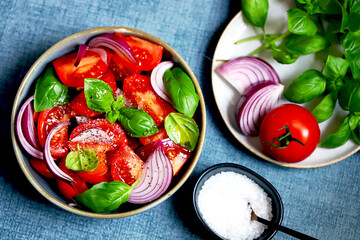 Wall Mural - Bright healthy salad with tomatoes, basil and blue onions.