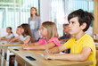 © JackF - Portrait of focused preteen schoolboy writing exercises in workbook during lesson in classroom ..