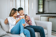 © Johnstocker - Happy Young Asian couple use smartphone enjoy to play game