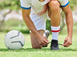 Sports, soccer and man tie shoe on field, ready for game, match and outdoor training. Fitness, exercise and soccer player tying shoelace on sneaker before workout on soccer field for good performance