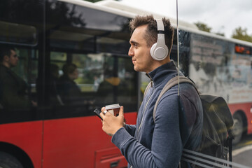 Wall Mural - One man young adult male stand at public transport bus station waiting