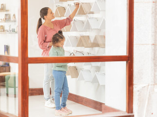 Wall Mural - Eyewear, vision and family with a mother and daughter in an optometry store shopping for prescription lenses together. Family, retail and glasses with a woman customer buying spectacles for a girl