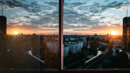 Sticker - Aerial view of train on railway surrounded by buildings in Berlin during sunset