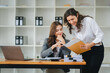 © Daenin - Two diverse female designers smile as they work together at a conference room table during a meeting in a modern office. collaboration concept