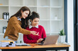 © Daenin - Two diverse female designers smile as they work together at a conference room table during a meeting in a modern office. collaboration concept