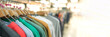 Banner. Clothes on hangers - new fashion collection at fashionable clothes store. Clothing rental, thrift shopping or seconhand store. Clothes stall against blurred store background with copy space