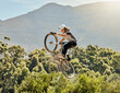 © Delcio F/peopleimages.com - Sport, action and biker doing jump in air with mountain bike for extreme sports, adrenaline and hobby. Fitness, adventure and woman on bike doing trick shot, jumping and stunt on bicycle in nature