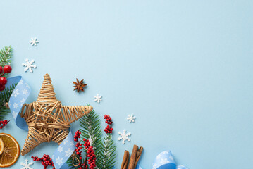 Wall Mural - New Year concept. Top view photo of wicker star ornament mistletoe berries pine branches curly ribbon anise dried orange slices cinnamon snowflakes on isolated light blue background with empty space