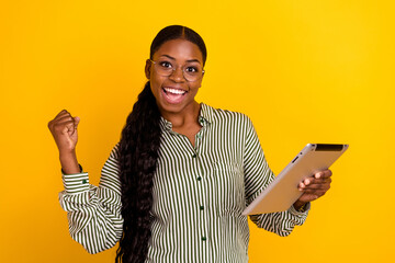 Wall Mural - Photo of impressed millennial brunette lady hold talblet yell wear eyewear striped blouse isolated on yellow color background