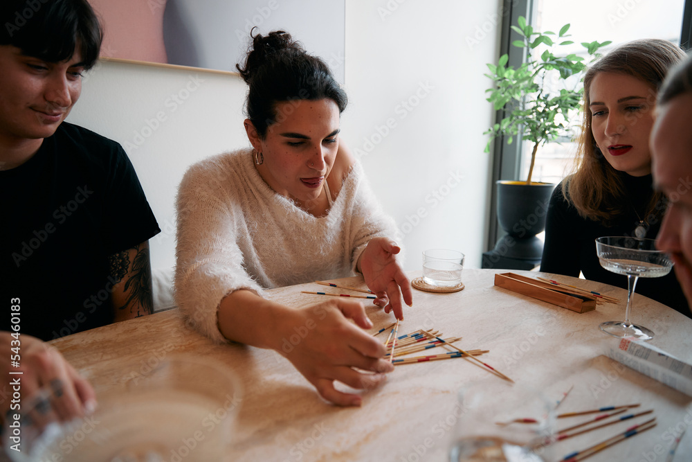 Young people playing pick up sticks