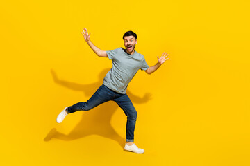 Poster - Full length photo of active overjoyed young man dancing toothy smile isolated on yellow color background