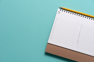 close up of calendar and pencil on the green table background, planning for business meeting or travel planning concept