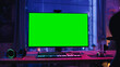© Gorodenkoff - Gaming at Home: Empty Gamer Station with Player's Personal Computer with Green Screen Chroma Key Display Standing on a Wooden Desk in Cozy Loft Apartment with Neon Lights.