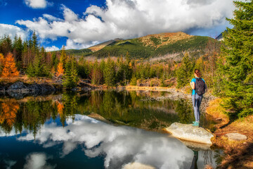 Wall Mural - Tourist woman on the shore of mountain lake Rakytovske pliesko in High Tatras mountains in Slovakia