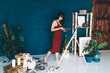 © BullRun - Female artist painting on canvas in studio