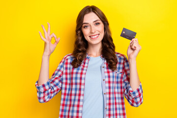 Canvas Print - Photo of charming cute girl dressed checkered shirt rising debit card showing okey sign isolated yellow color background