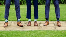 Men With Creative Sock Designs Standing Outside On A Wedding Day