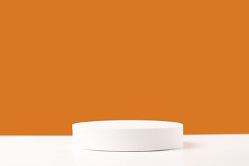 Wall Mural - Empty white round podium stage on orange backdrop. Mockup scene for product presentation. Studio photography. Product showcase or display.