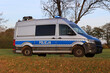 Samochód służbowy polskiej policji państwowej podczas akcji na drodze za miastem. 