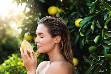 Wall Mural - Beautiful woman with smooth skin with a lemon fruit in her hands