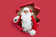 © ZaStock - Emotianal Santa Claus confidently walks through the paper hole into new year. Christmas advertising
