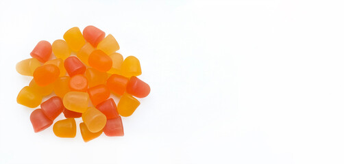 Wall Mural - Close-up texture of orange and yellow multivitamin gummies in the form of bears on white background. 