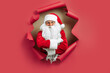 © ZaStock - Santa Clause looking through hole on red paper while standing with crossing hands. New Year advert