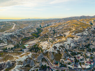 Wall Mural - Panoramic drone view of fairy chimneys mountain valley, unique geological formations, and the city in Cappadocia, the Central Anatolia Region of Turkey. High quality photo