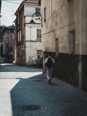 Wall Mural - man in the white clothes on the old pavement street