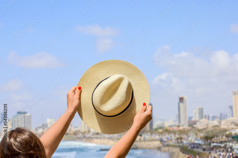 Woman with stylish hat near sea, back view