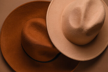 Wall Mural - Closeup view of stylish felt hats on brown background