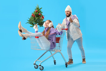 Sticker - Young couple with Christmas tree and shopping cart on blue background