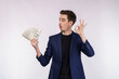 © Johnstocker - Portrait of a cheerful man showing Ok sign and holding money over white background