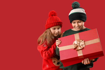 Sticker - Little children opening Christmas gift on red background