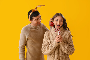 Canvas Print - Young couple in love with Christmas decor on yellow background