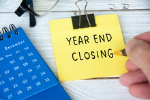 Year End Closing Written On Yellow Notepad With December Calendar And Glasses Background. Year End Closing Concept.