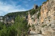 Asphalt road with rocky cliffs with plants near hiking forest in Siurana de Prades, Spain