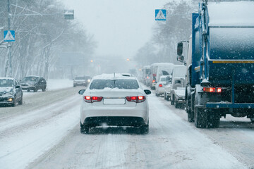 Traffic jam on city street in snowfall