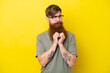 Redhead man with beard isolated on yellow background scheming something