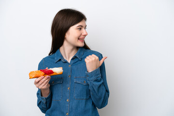 Wall Mural - Young Russian woman holding sashimi isolated on white background pointing to the side to present a product