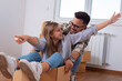 © Dexon Dee - Happy couple is having fun with cardboard boxes in new house at moving day.
