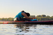 © watcherfox - Middle aged woman doing yoga on sup board in the river. Meditative pose, side view - concept of harmony with the nature, free and healthy living