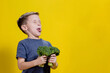 A charming little boy refusing to eat broccoli. Brootish broccoli