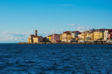 Wall Mural - The waterfront of the historic medieval town of Piran on the coast of Slovenia. On the far left is the Our Lady of Health Church and a 17th century lighthouse tower 
